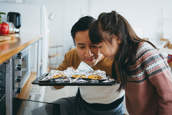 Vater und Kind backen Kekse und riechen daran