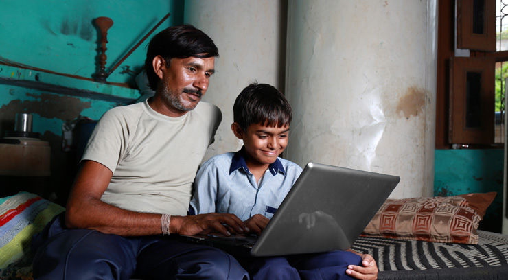 father and son using laptop