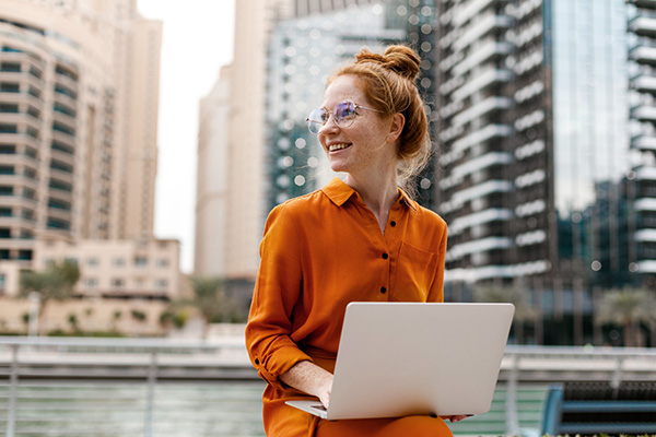 Woman sitting outside working on a laptop