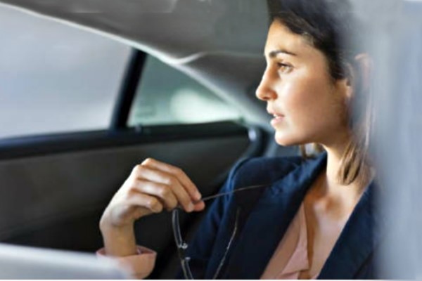 Woman in a car holding a pair of glasses 