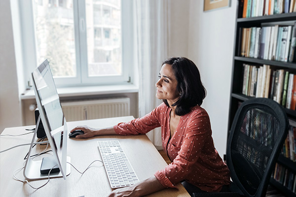 Femme travaillant sur un moniteur grand écran.